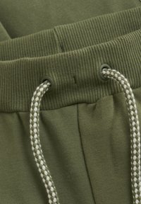 Olivgröna sweatpants med ribbad midja, metallöglor och ett strukturerat vitt och olivfärgat dragsnöre. Mjukt tyg med avslappnad passform.