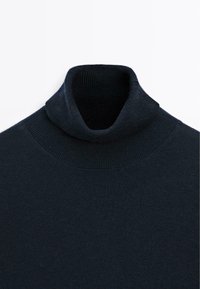 Navy turtleneck sweater made from a smooth, stretchy fabric. Features a snug, ribbed collar and clean stitching along the shoulders.