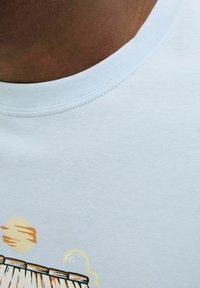 Lichtblauwe katoenen T-shirt met een ronde halslijn, met een grafisch ontwerp van een zon en golven in warme kleuren. Soepele textuur, casual ontwerp.