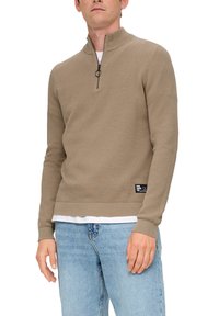 Beige Strickpullover mit hohem Kragen und halbseitigem Reißverschluss. Verfügt über gerippte Bündchen und Saum, strukturierte Stoffqualität und ein Logo-Patch am unteren Ende.