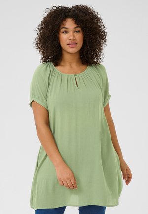 Light green, loose-fitting tunic with short rolled sleeves, pleated neckline, and a keyhole accent. Soft, textured fabric.