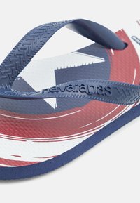 Infradito blu e rossi con suola in gomma decorata, dotate di cinturini blu navy e un design a stelle bianche sulla soletta. Superficie testurizzata per una migliore aderenza.