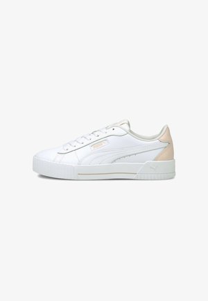 Białe niskie buty sportowe Puma z beżową pętelką na pięcie, sznurowaniem z przodu i fakturowaną podeszwą na jednolitym białym tle.