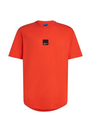 T-shirt rouge à manches courtes en tissu lisse, avec un col rond et une petite étiquette logo noire sur la poitrine. Ourlet arrondi.