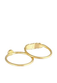 Goldfarbener Ring-Satz mit einem glatten Band und einem gewellten Design auf einem anderen Band. Die Markierung "925" befindet sich auf der Innenseite.