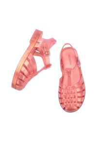 Pink transparent jelly sandals with a woven design, buckle closure, and metallic shimmer finish. Flat sole for comfort and stability.