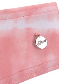 Tissu rose avec un motif tie-dye, présentant une texture lisse et un pendentif rond argenté portant l'inscription "s.Oliver". Détails de couture visibles le long du bord.