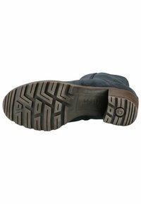 Botín de ante negro con una suela de goma texturizada que presenta un patrón de banda de rodadura en zigzag. Incluye un logo circular en el lateral de la suela.
