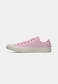 Rosa kanvas sneakers med lavt snitt, teksturert overflate, hvit gummitå og hevet spiker langs hælen.