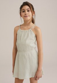 Svetlozeleno brezrokavno oblačilo z nabranim izrezom, teksturirana tkanina z majhnimi, dvignjenimi pikami in prilegajočim pasom.