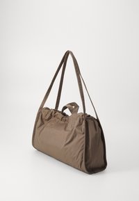 Bruine nylon tote bag met een gathers op de bovenkant, twee lange hengsels en een klein handvat bovenop. Heeft een zachte, gemarmerde oppervlakte.