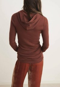 Smešani smeđi dukserica s kapuljačom dugih rukava od mekog materijala, s uskim krojem i naborima sa strane, u kompletu s odgovarajućim hlačama.