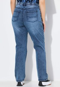 Pantalones de mezclilla azul claro con un diseño de pierna recta, que cuentan con dos bolsillos traseros y una textura sutil. La cinturilla es elástica.