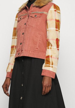 Jacke in Rostfarbe mit Kunstpelzkragen, karierte, flauschige cremefarbene, orange und rosa Ärmel, kombiniert mit einem schwarzen Rock mit Knopfleiste vorne.