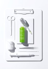 Grön Murad serumflaska, vit spruta, sax, pincett, bomullspad och andra verktyg på en vit clipboardbakgrund.