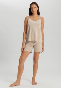 Conjunto de ropa de descanso beige que incluye una blusa sin mangas con encaje y pantalones cortos a juego. Tela suave y ligera con un ajuste holgado.