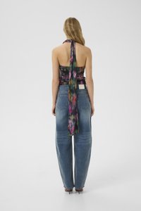 Floral halter top with a trailing back, paired with high-waisted, loose-fitting blue denim jeans. Smooth texture and vibrant patterns.