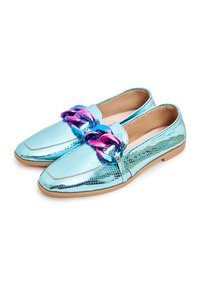Mocassins métalliques bleu clair avec un motif texturé et un grand détail de chaîne bleu violet sur une semelle basse de couleur tan, présentés côte à côte.