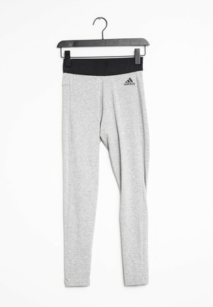 Leggings deportivos grises con una cintura negra que presenta el logo de "adidas". Textura lisa y diseño ajustado, colgados de una percha negra.