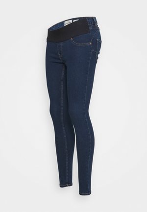 Mørkeblå skinny graviditetsjeans med sort stretchlinning og lommer foran og bagpå mod en hvid baggrund.