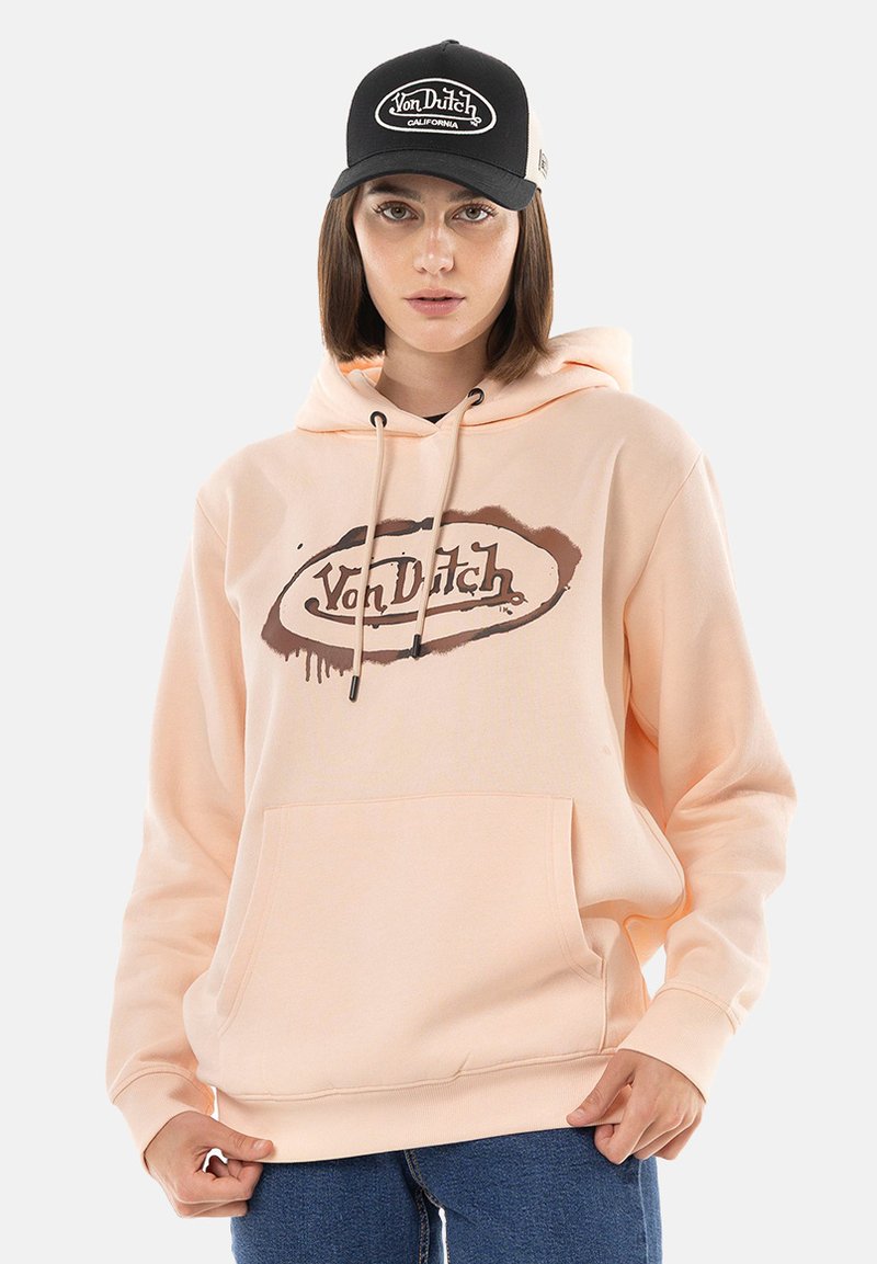 Sweat à capuche pêche avec une poche avant, des cordons de serrage et une impression de logo. Associé à une casquette noire avec un logo brodé blanc.