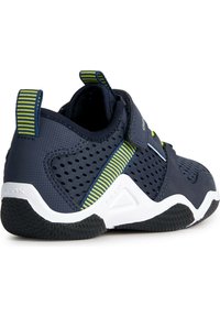 Zapatillas deportivas de color navy con materiales de malla y sintéticos, con rayas verdes y un collar acolchado. Suela texturizada notable con patrones de agarre.