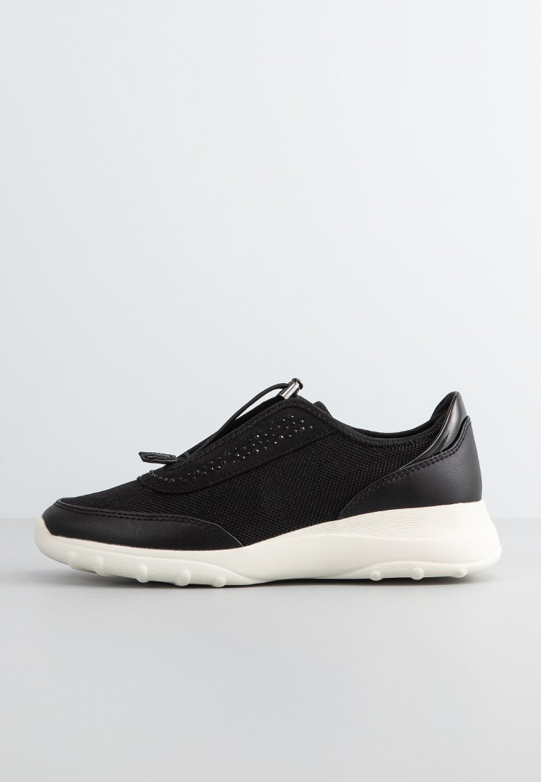 Zapatillas deportivas negras con una combinación de tela de malla y cuero sintético, diseño sin cordones y una suela de goma blanca con acentos texturizados.