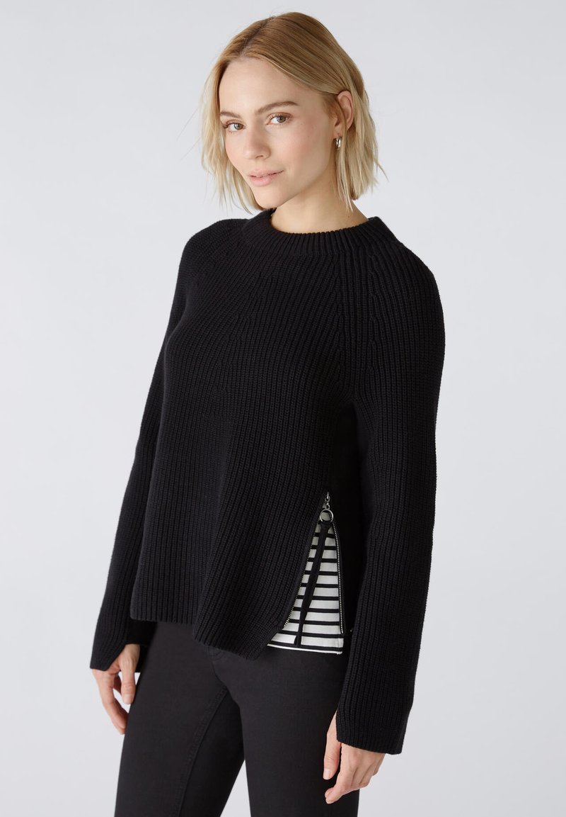Schwarzer gestrickter Pullover mit langen Ärmeln und geripptem Stoff. Verfügt über seitliche Reißverschlüsse, die eine gestreifte innere Schicht offenbaren. Rundhalsausschnitt-Design.