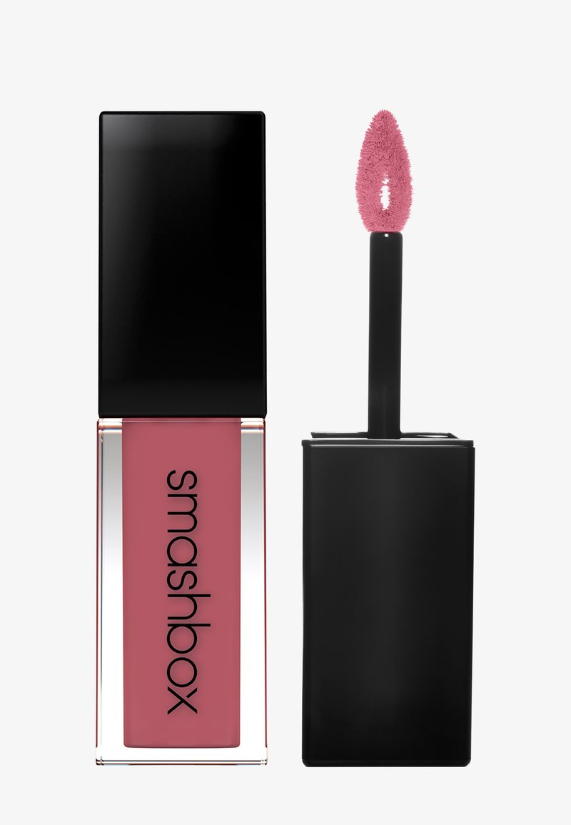 Flüssige Lippenfarbe in einem rechteckigen, klaren Behälter mit einem pinken Farbton. Enthält einen schwarzen Applikator mit einem fuzzeligen Wand mit pinker Spitze.