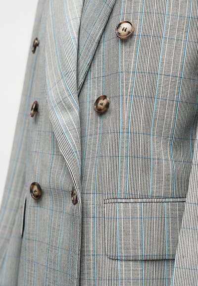 Δίπλας σακάκι με γκρι και μαύρο πρότυπο κυνόδοντα με μπλε ρίγες, επτά κουμπιά και λεπτομέρεια πλαϊνής τσέπης.