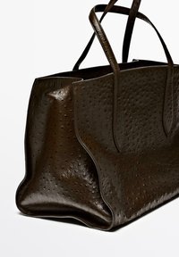 Ostrich leather tote bag in dark brown, featuring a textured surface with small bumps, dual handles, and a spacious design.