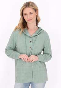 Maglione con cappuccio verde menta e texture a trecce, caratterizzato da un'apertura con bottoni e maniche lunghe, progettato con una vestibilità rilassata.