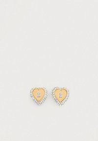 Ασημί καρφωτά σκουλαρίκια σε σχήμα καρδιάς με χρυσή τρύπα κλειδιού στο κέντρο, περιτριγυρισμένα από μικρές διαφανείς στρας για επιπλέον λεπτομέρεια.