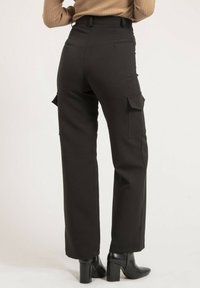 Pantalons cargo noirs à taille haute, dotés de poches latérales et d'un design droit, fabriqués dans un matériau structuré.