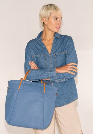 Blaues Leder-Umhängetasche mit hellbraunen Ledergriffen. Verfügt über ein nahtloses Design und sichtbare Nähte an der Vorderseite. Logo "a/u" geprägt.