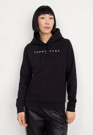 Sudadera negra con cordones, bolsillo frontal y "TOMMY JEANS" impreso en blanco en el pecho. Fabricada con una suave tela texturizada.