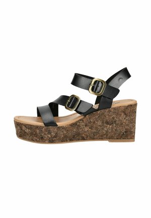 Czarna sandałka na koturnie z paskami, dwoma złotymi klamrami oraz korkową platformą, z odkrytymi palcami i paskiem wokół kostki.