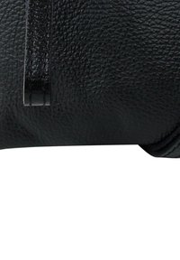 Zwarte leren portemonnee met een getextureerd oppervlak, voorzien van een gestikte accent en een slank, rechthoekig vorm. Minimalistisch ontwerp zonder zichtbare hardware.