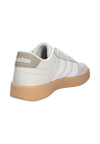 White leather sneaker with a textured finish, gray accents, three white stripes, and a tan rubber sole. Features padded collar and tongue.