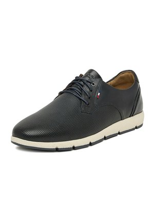 Scarpa casual da uomo in pelle nera con lacci, parte anteriore texturizzata, suola beige e piccola etichetta in tessuto rossa, bianca e blu sul lato.