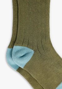 Par de calcetines de punto verde oliva con talones reforzados azul claro y puños acanalados sobre un fondo blanco.