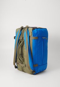 Sac à dos avec un design bleu et vert olive, doté de bretelles en tissu, d'une poche latérale et d'une fermeture éclair pour un rangement sécurisé.