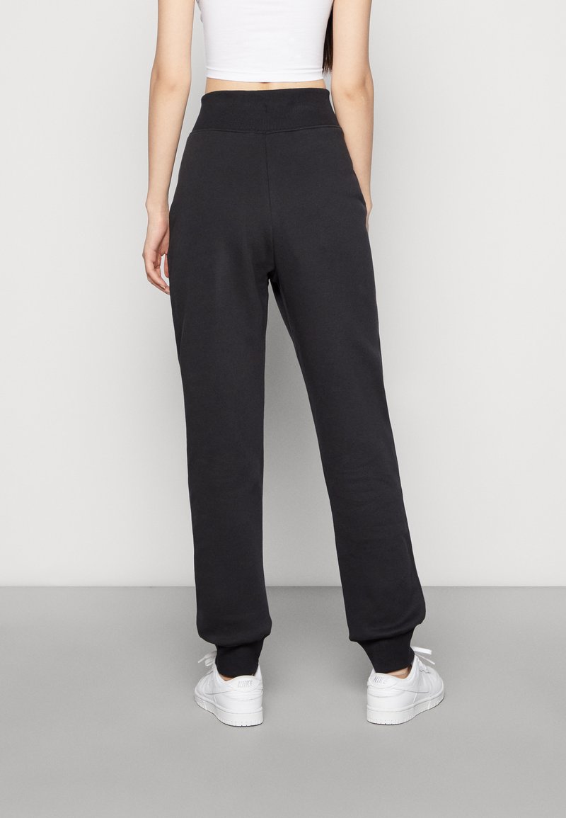 Pantalones de chándal negros con una cintura alta elástica y puños acanalados. Hechos de una tela suave, con un corte relajado y sin patrones o logotipos visibles.