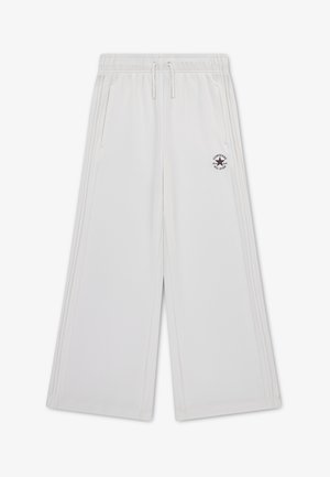 Hvide vidde joggingbukser med elastisk talje, snøre, sidelommer, sidestreger og et lille sort Converse All Star-logo på venstre lår.