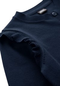 Cardigan en maille bleu marine avec un col rond, deux boutons et des accents à volants le long des épaules. Texture douce, finition lisse.