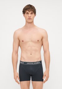 Boxer shorts neri con un design della cintura logo. Realizzati in tessuto morbido, presentano una forma aderente e una consistenza liscia.