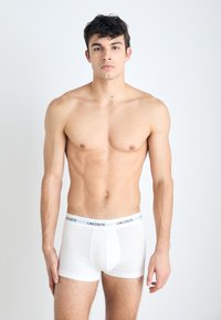 Witte katoenen boxershorts met een strakke pasvorm, voorzien van een zwarte elastische tailleband met merklogo. Het ontwerp is eenvoudig zonder extra patronen.