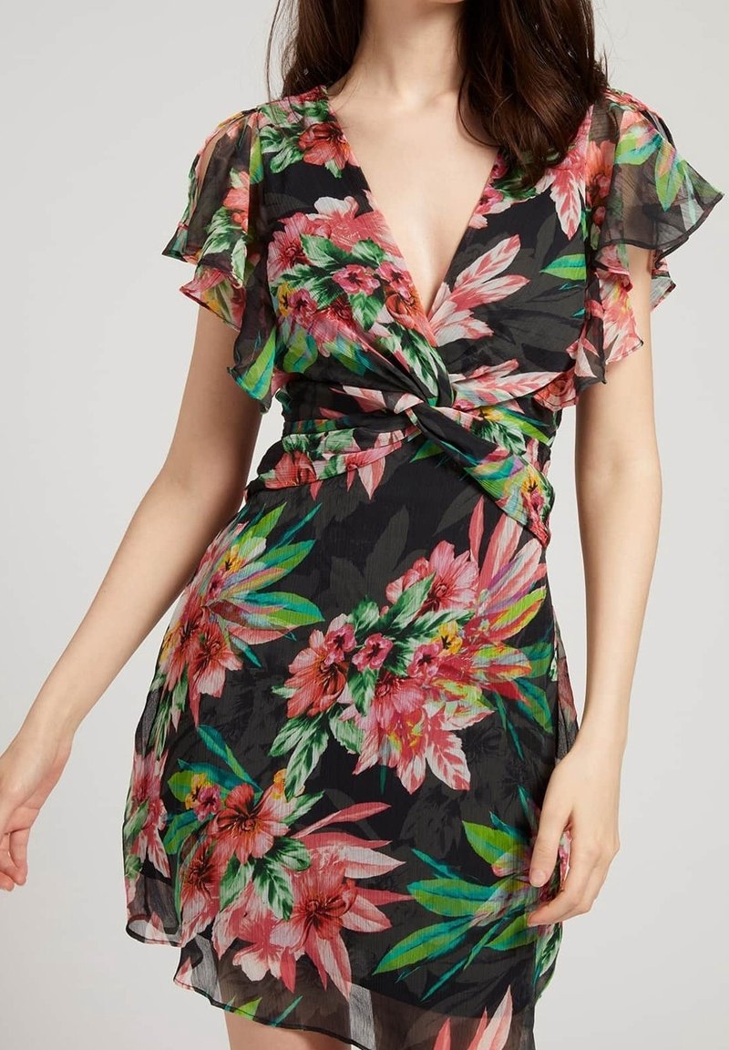 Robe portefeuille fleurie avec fond noir, présentant des fleurs roses et vertes, des manches courtes à volants et un détail de taille nouée.