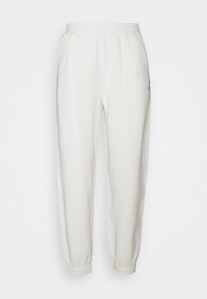 Pantaloni jogger con vita elastica bianca, polsini alla caviglia e cuciture verticali sottili sul davanti, mostrati su uno sfondo semplice.