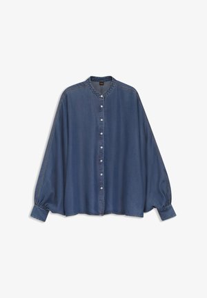 Blouse en denim bleu à manches longues avec col mandarin, fermeture à boutons sur le devant et poignets froncés sur fond blanc.